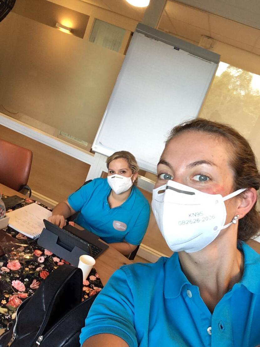 Foto van twee verpleegsters met mondkapjes die in de camera kijken